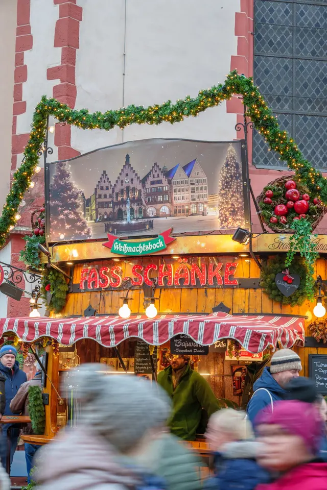 Visitors browsing a decorated Christmas market stall